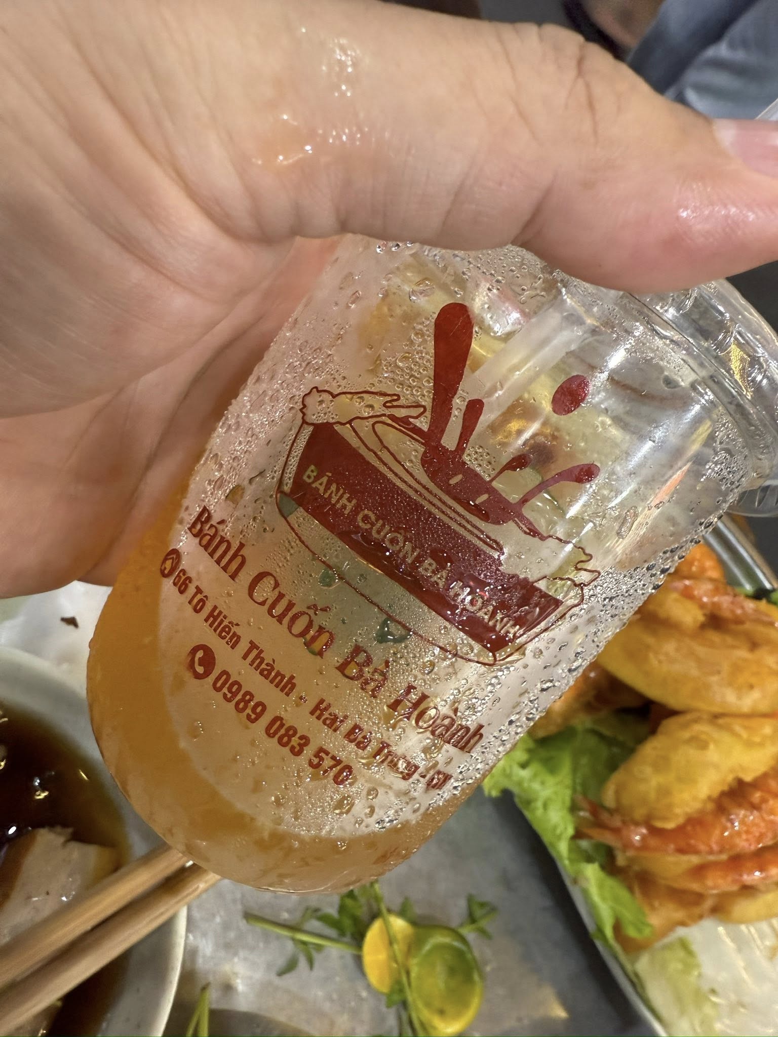 越南河內小吃店桌面上一杯裝滿冰塊與金桔片的金桔茶